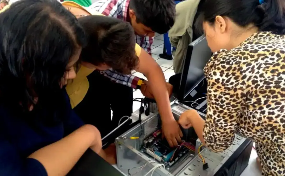 Estudiantes nayaritas utilizando computadoras y herramientas digitales en un aula tecnológica.